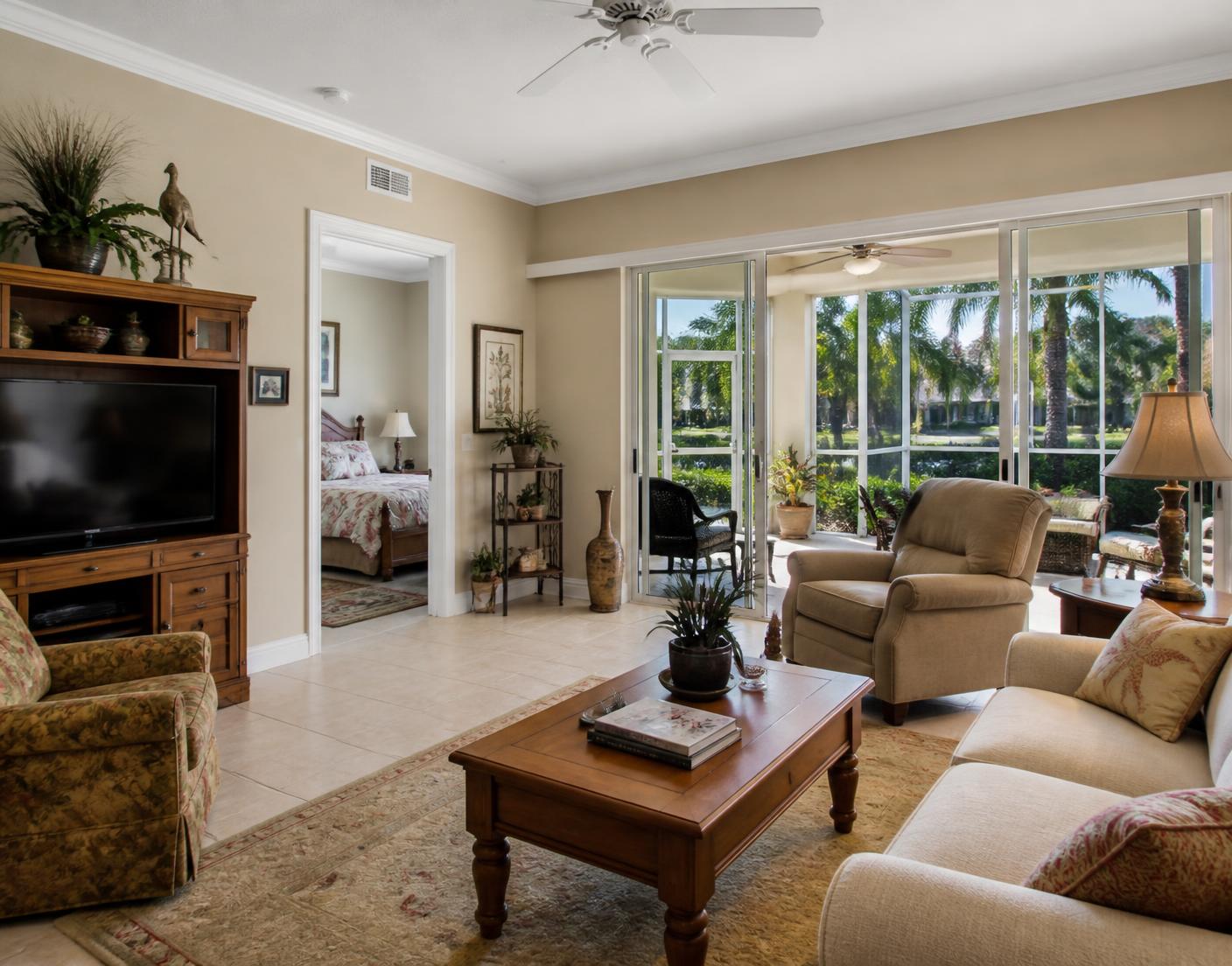 Comfortable, well kept Florida living room with tile floors and sliding doors opening to a screened lanai